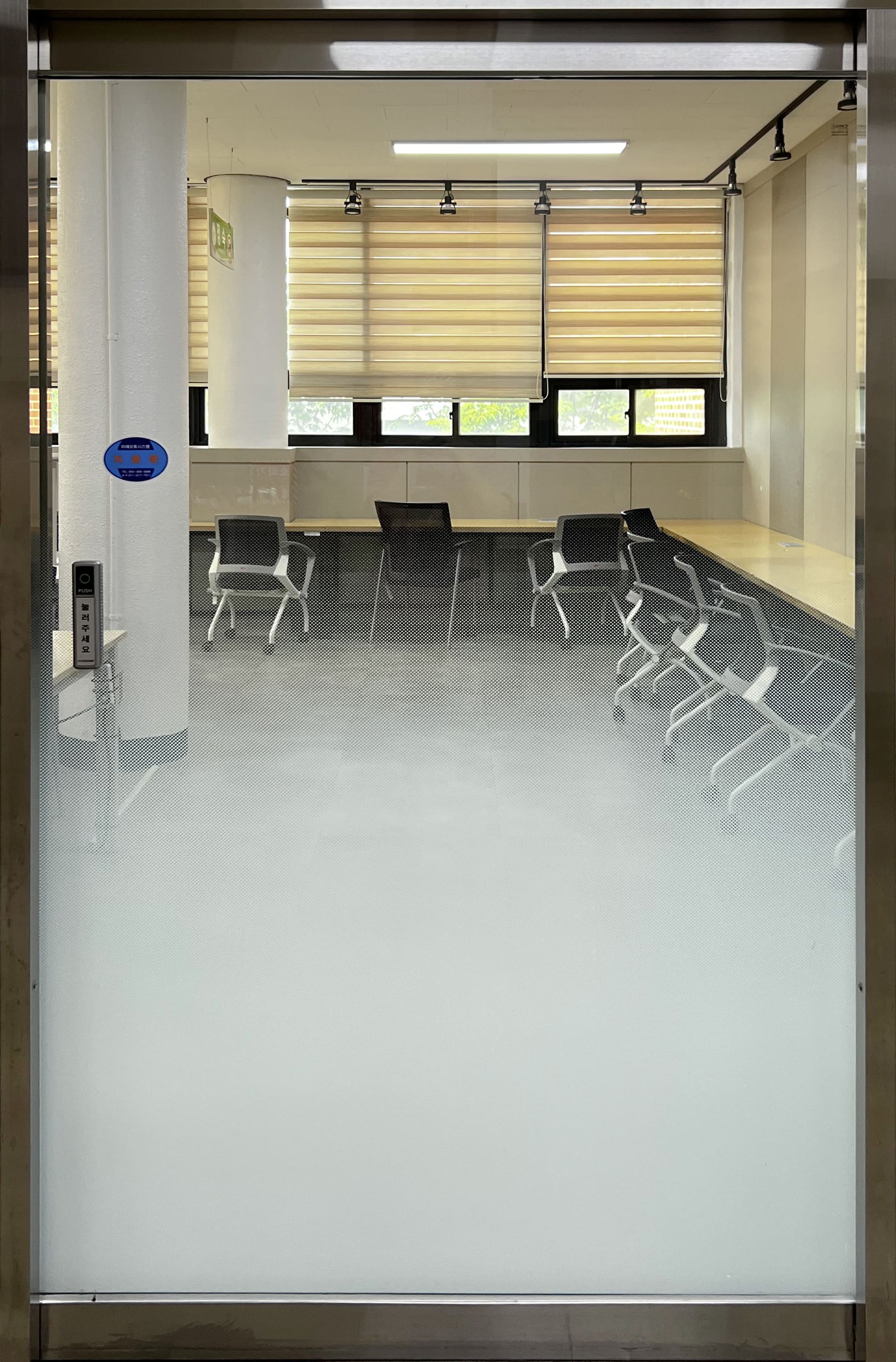 밑으로 갈수록 불투명해지는 투명 자동문.